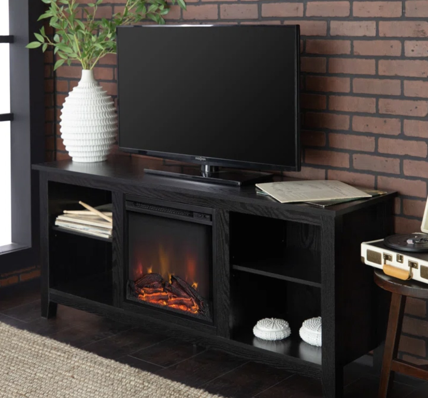 A black media console with a built in electric fireplace