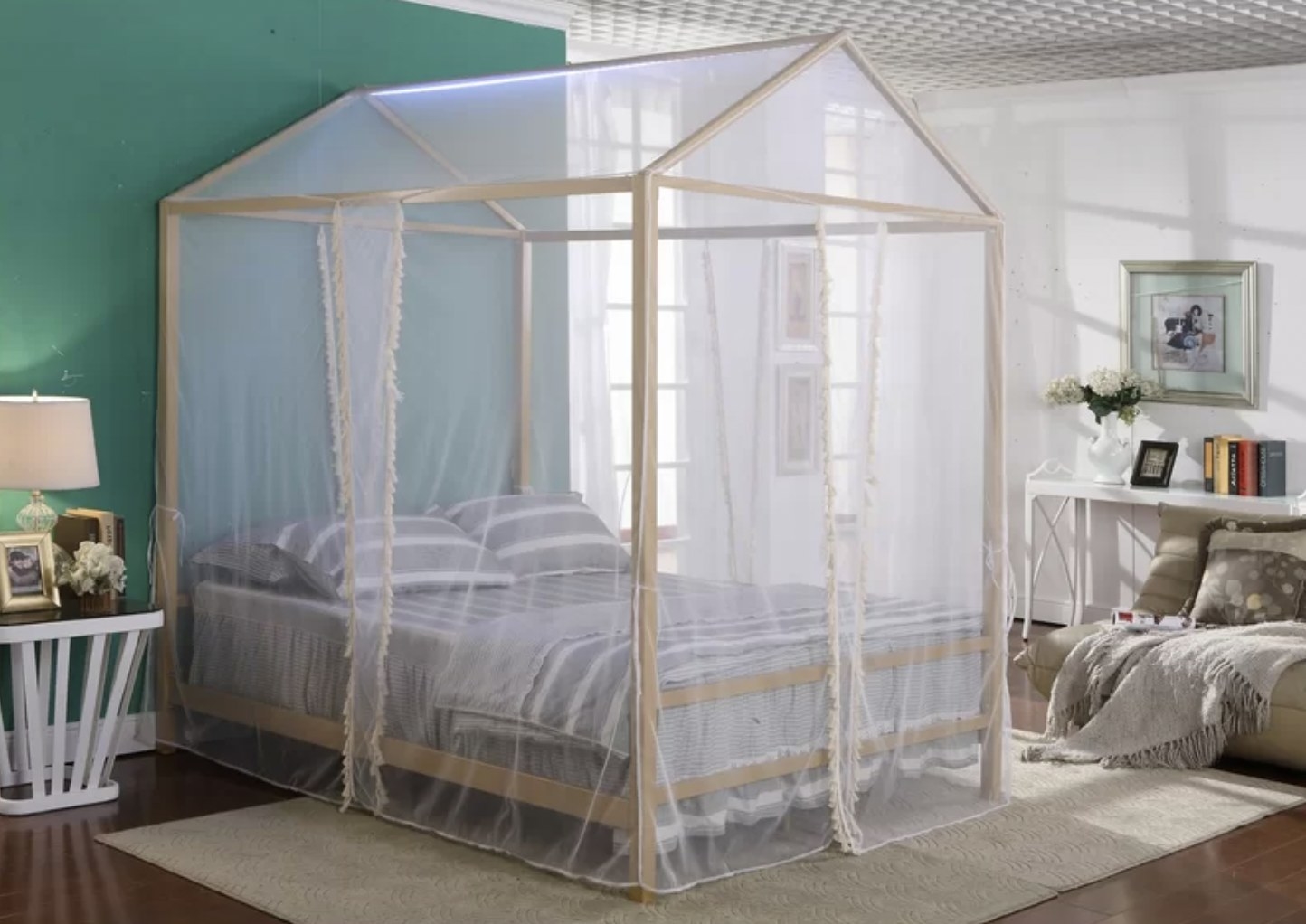 A child's canopy bed with grey linens