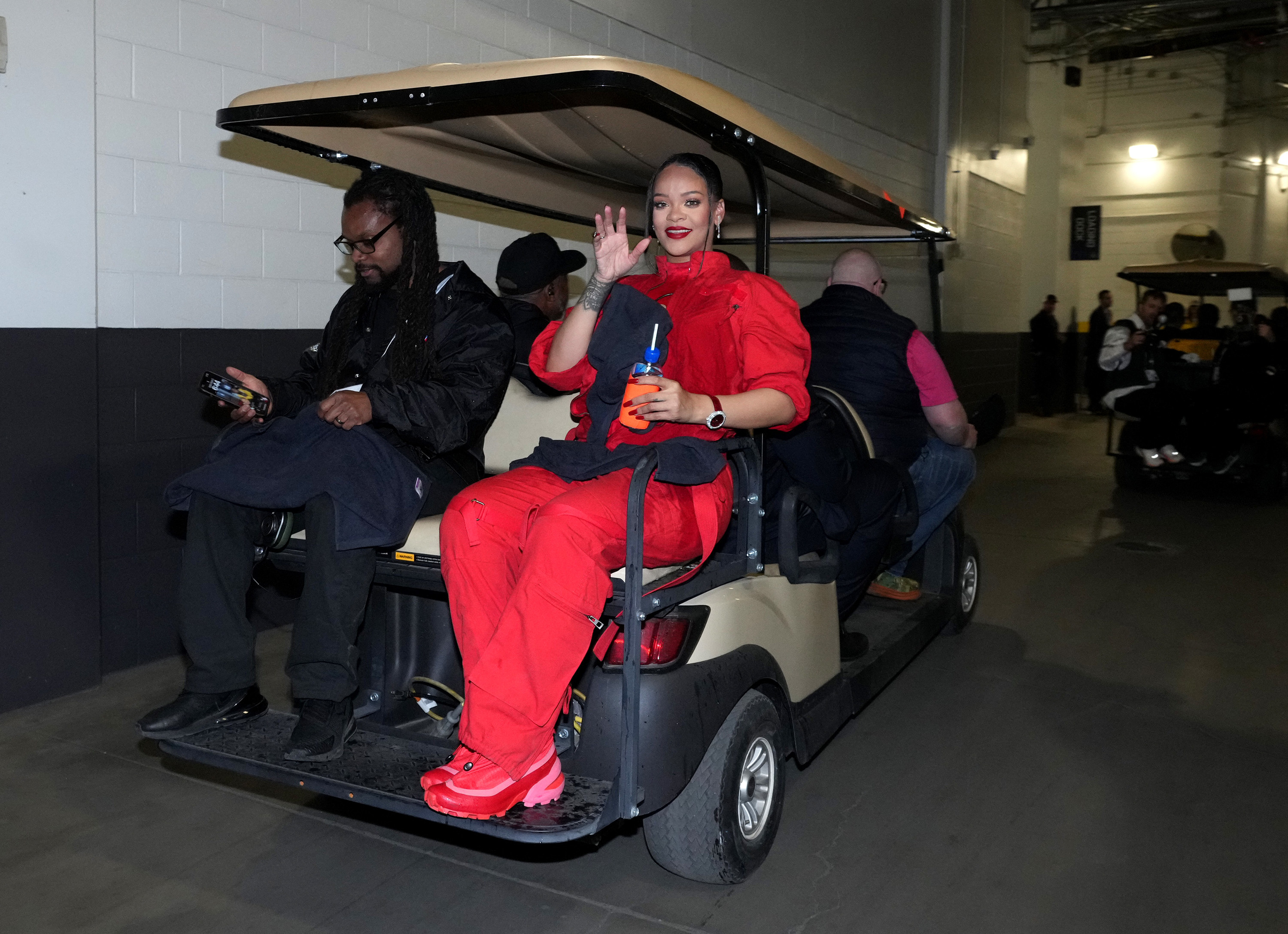 Rihanna waving from the back of a golf cart