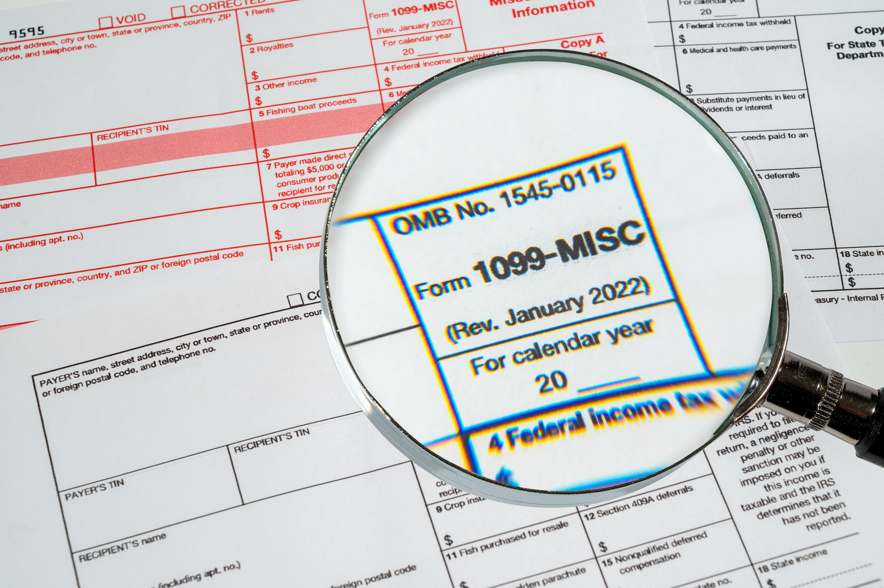 person looking at a 1099 form through a magnifying glass