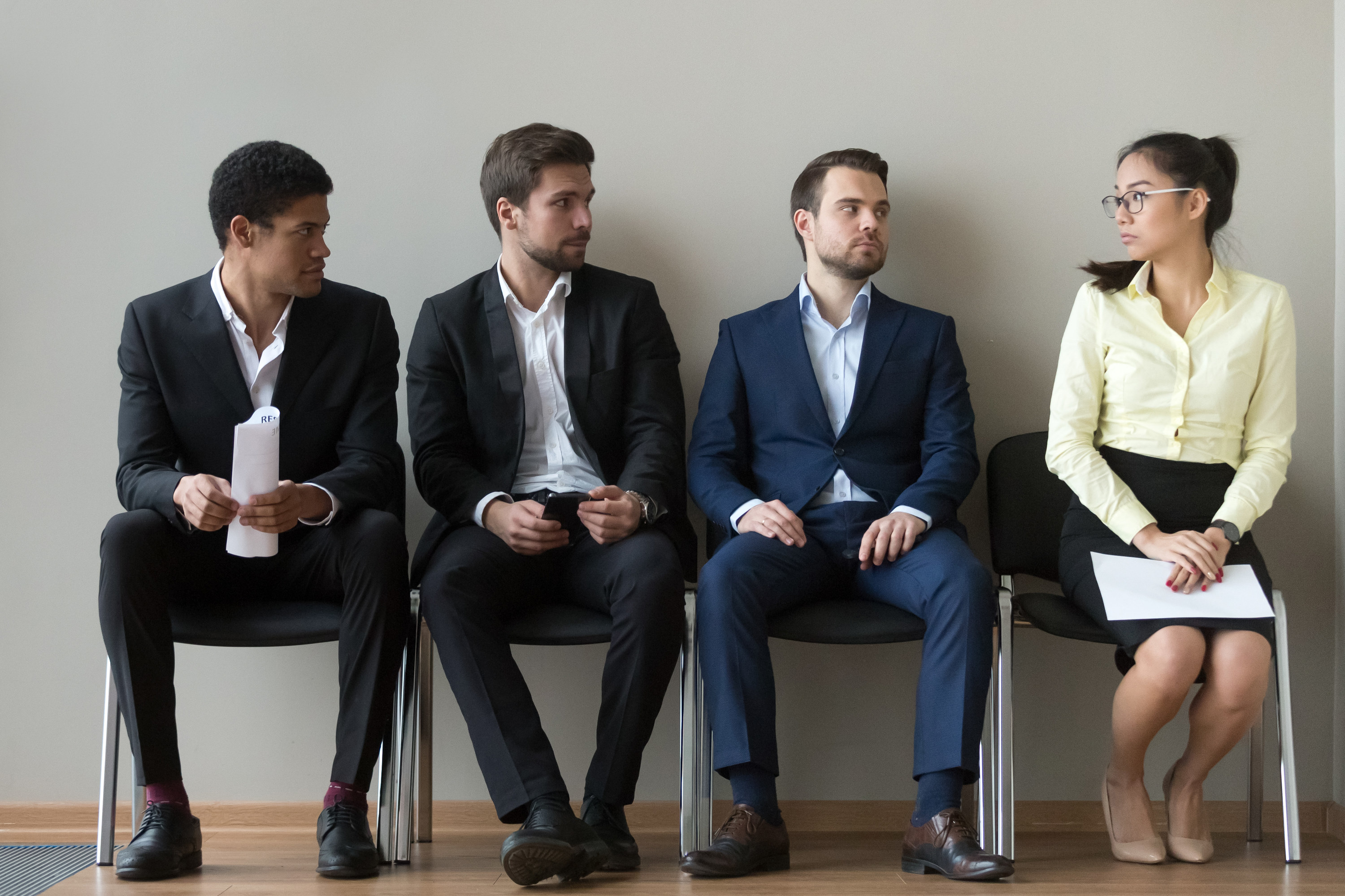 group of men in business suits looking at a woman who appears uncomfortable