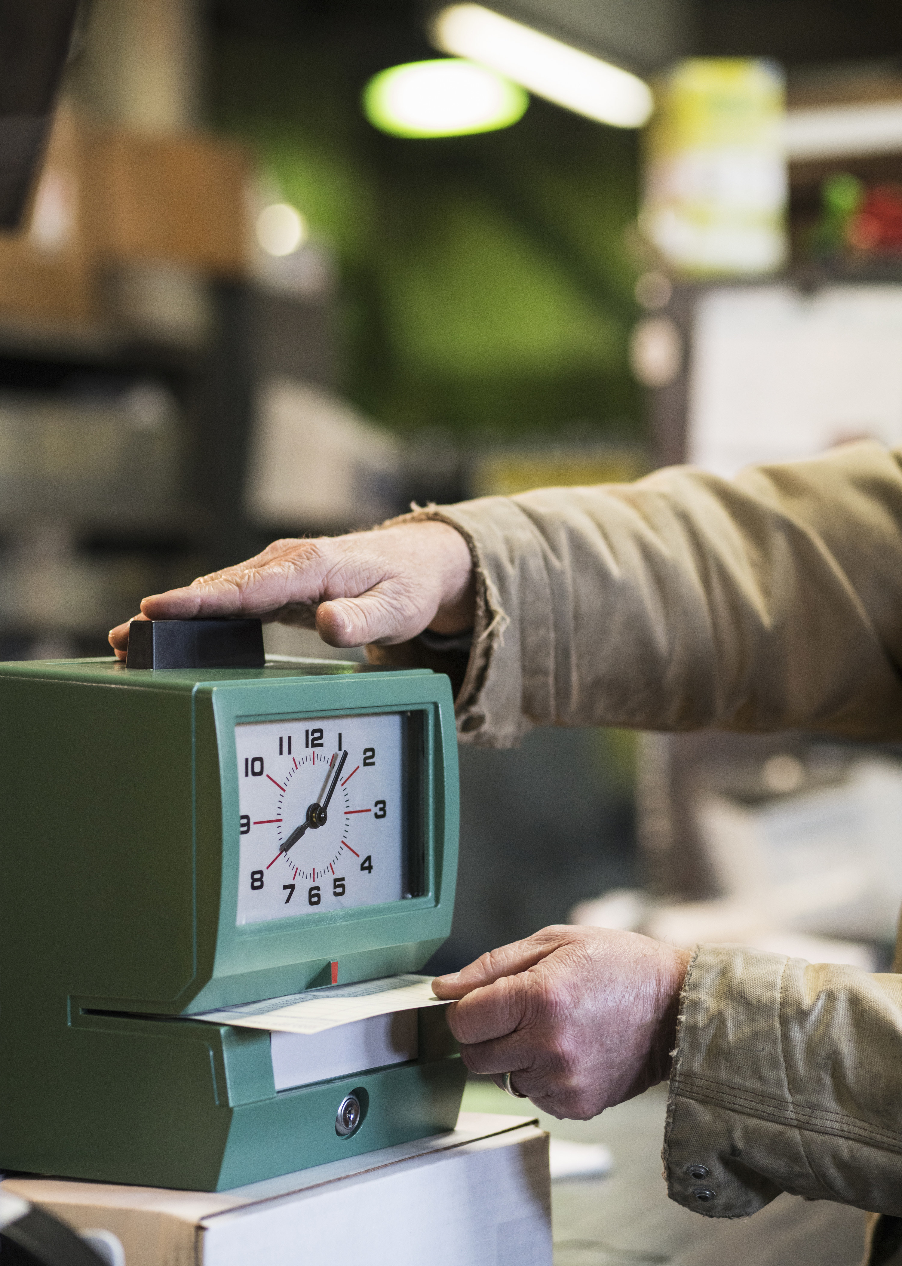 man clocking in using an old fashioned time clock machine