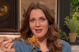 Drew Barrymore holding up some spaghetti to her mouth