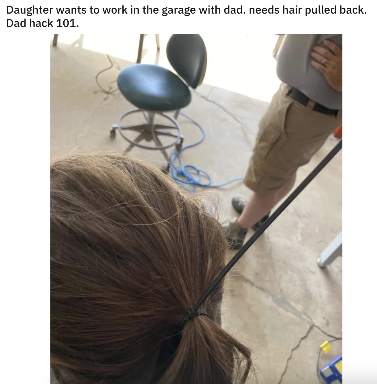 daughter working in the garage with her dad and needing her hair pulled back so dad uses a zip tie