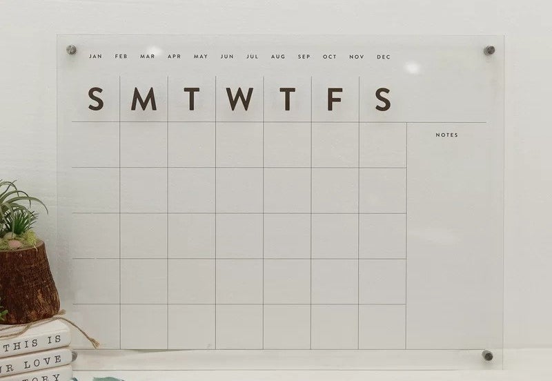 the clear wall-mounted calendar above desk