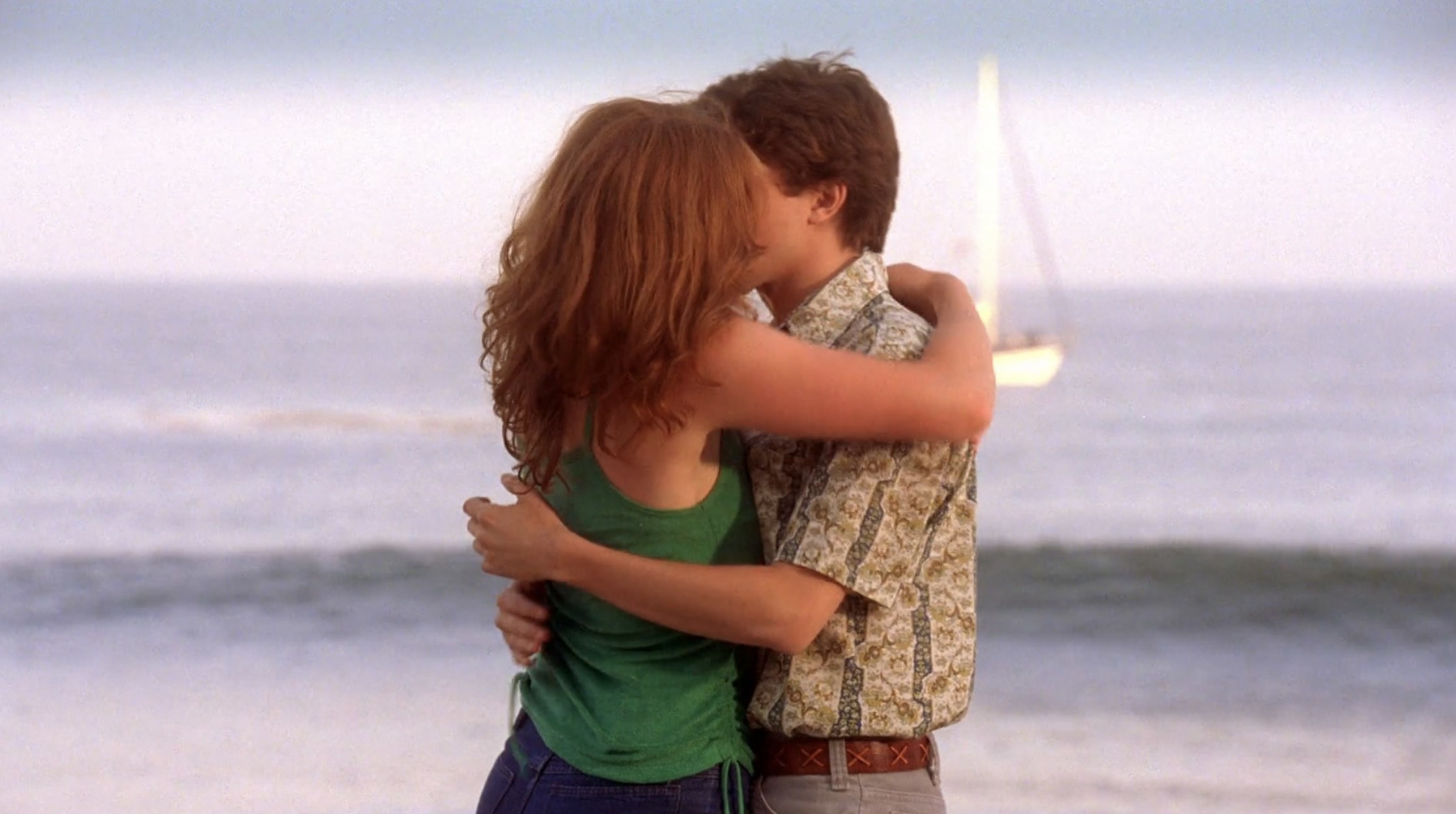 Eric and Donna embrace on the beach and share a kiss