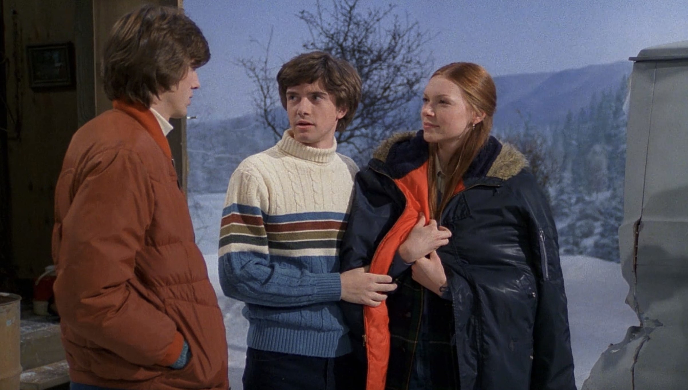Eric and Donna smile smugly at Kelso outside of the ice shack, while Eric drapes his jacket over Donna&#x27;s shoulders