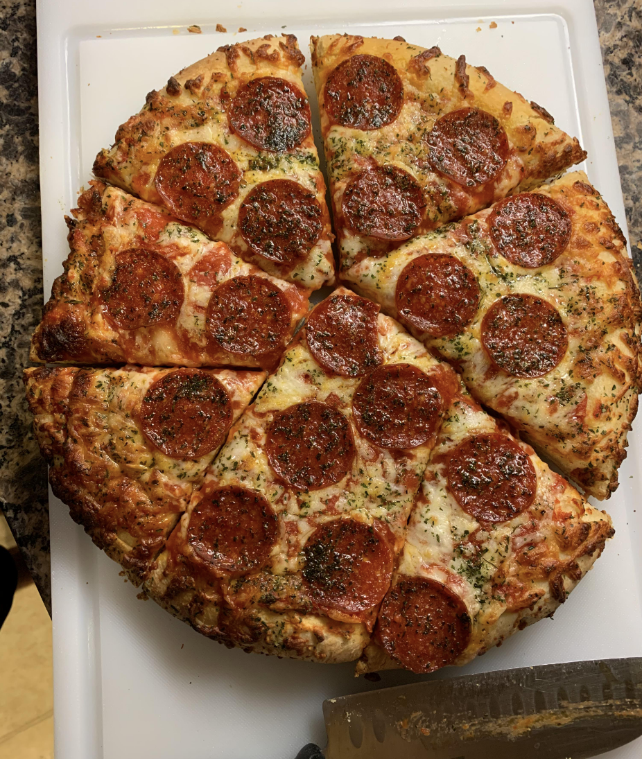 A pepperoni pizza has been cut with slices in bizarre and inconsistent shapes so the cutter avoided cutting through any individual pepperonis