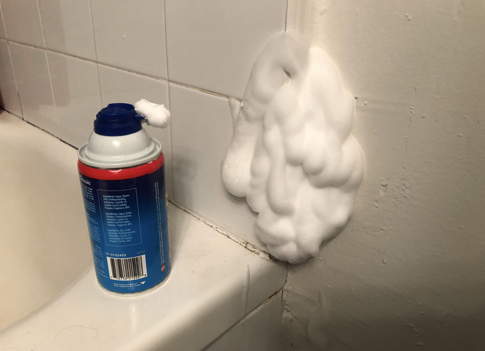 A large pile of shaving cream has been sprayed on the wall so you can&#x27;t see the spider