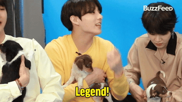 Gif of BTS member holding a puppy and saying &quot;legend&quot;