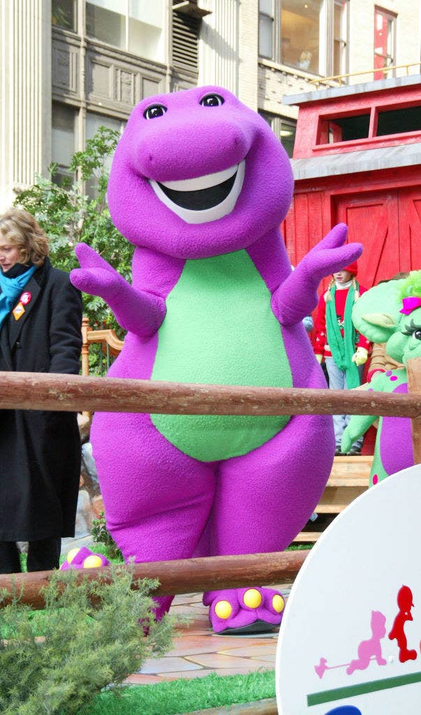 A Barney mascot smiling and waving at the Christina
