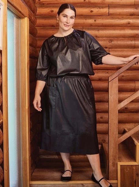 Model wearing black skirt with black top and black shoes