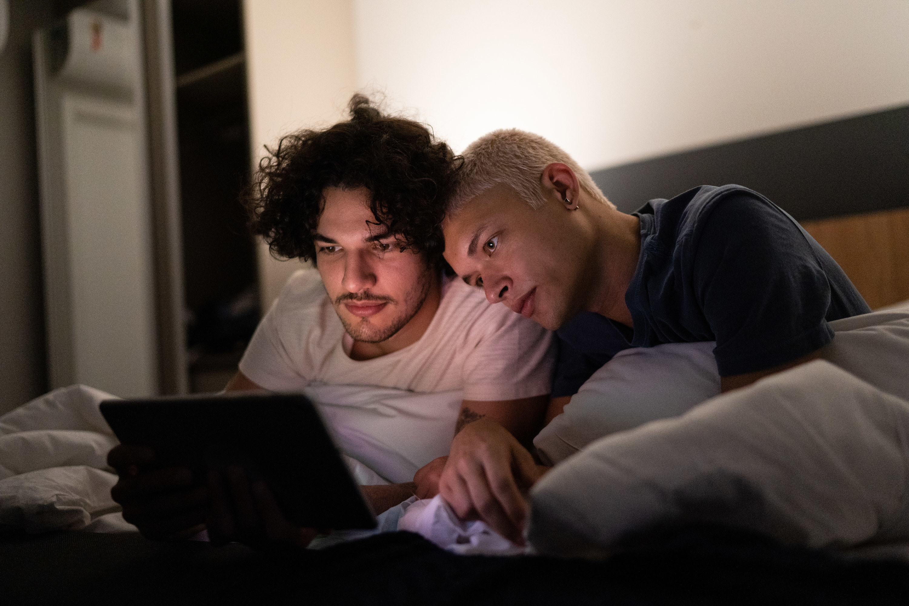 Two men watching TV together on a tablet