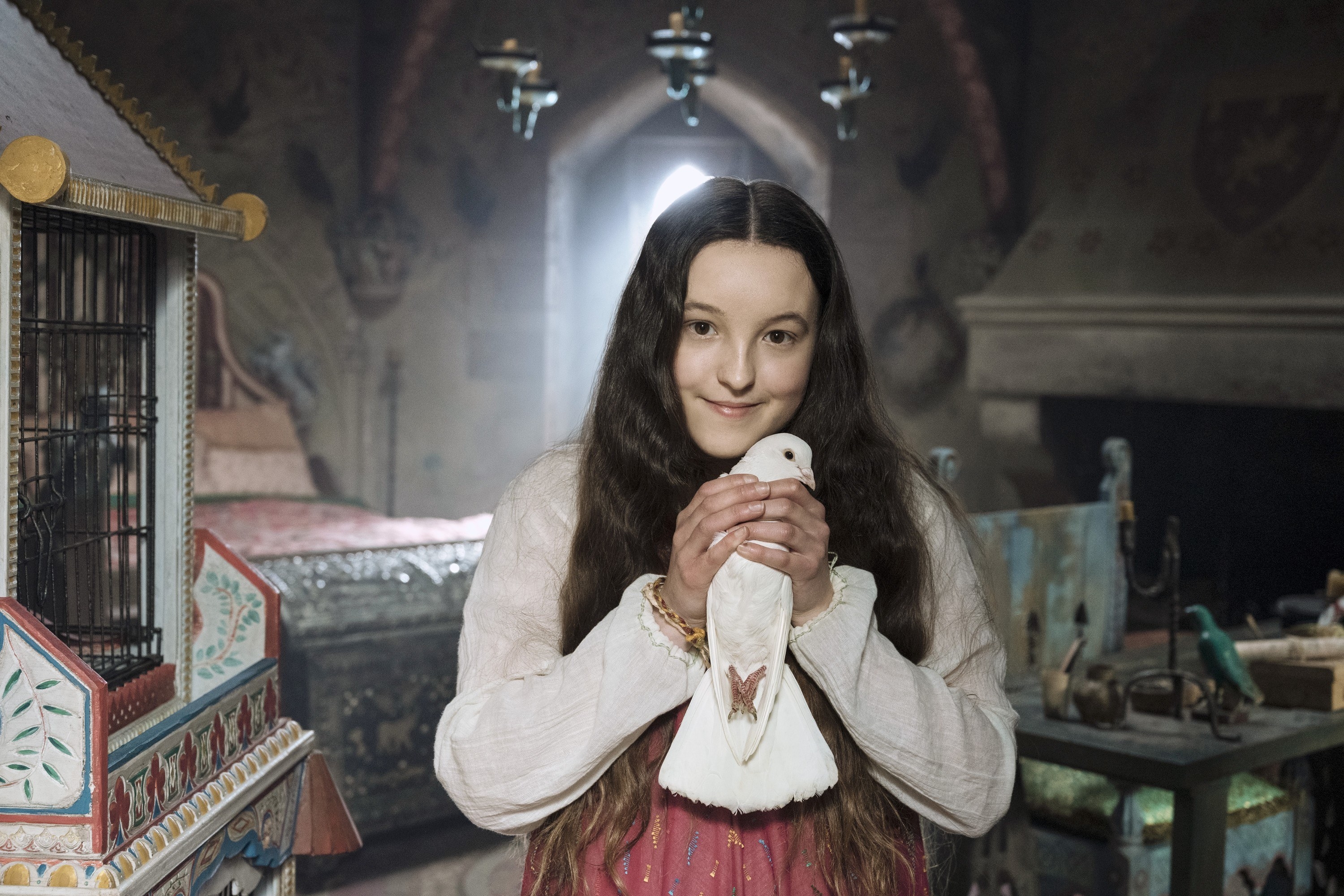 Bella holds a dove in her hands in Catherine Called Birdy
