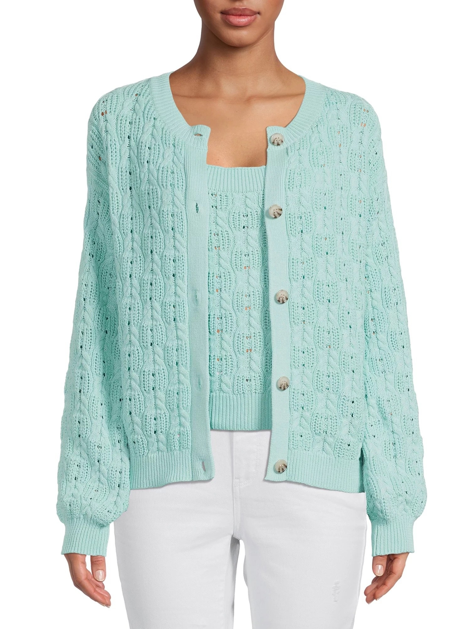 Model wearing mint green top with matching sweater and white jeans