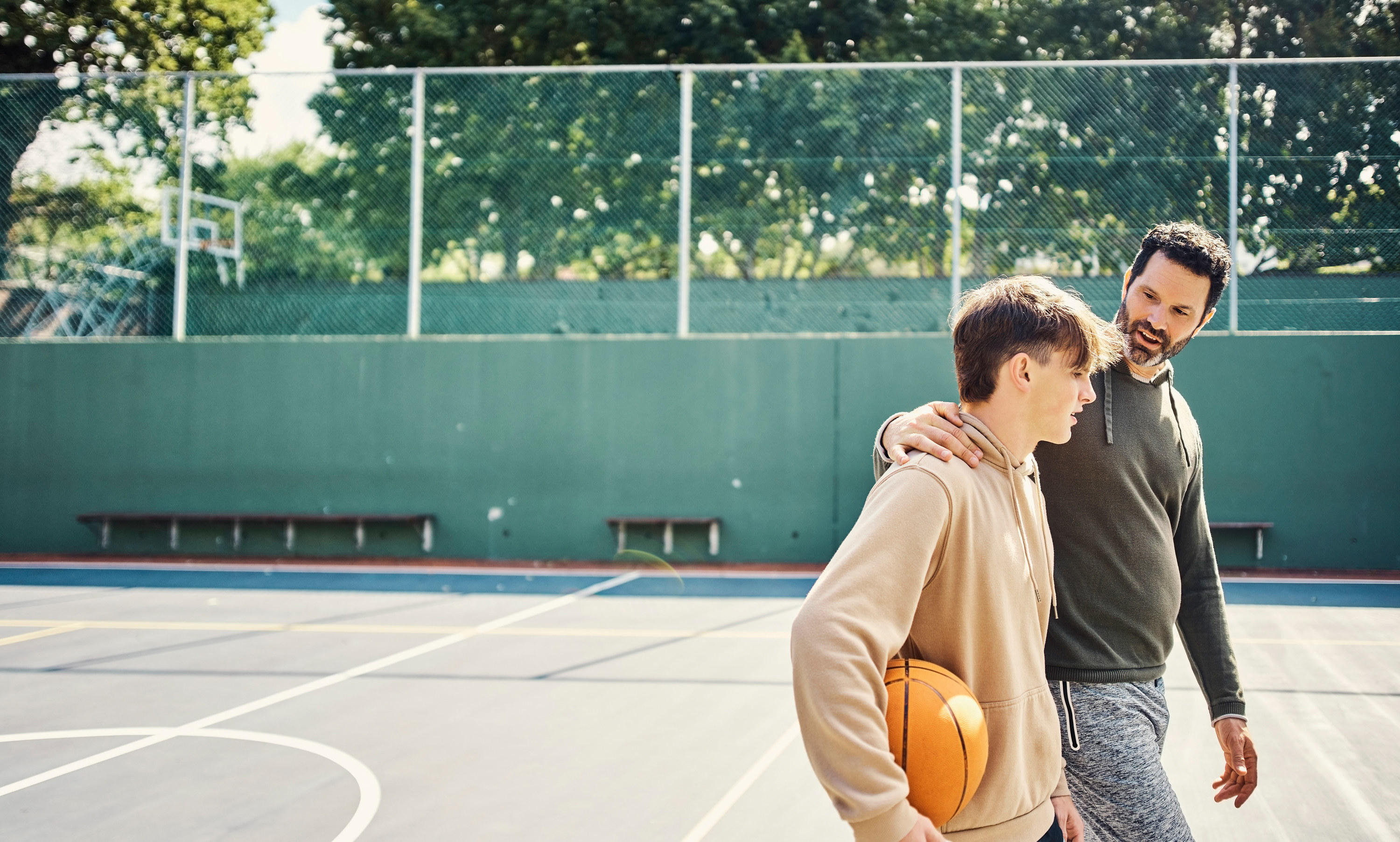 parents talking with kids on the basketball court