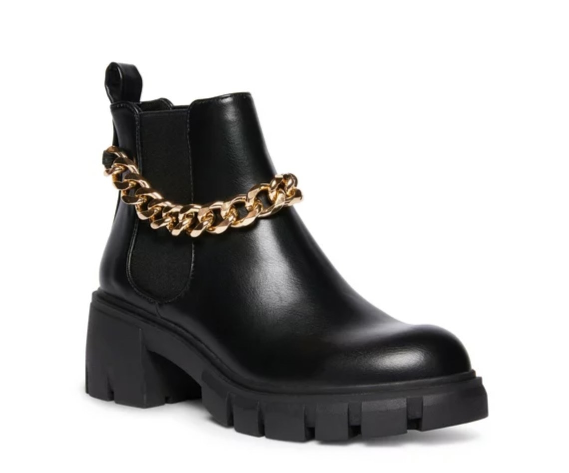 A black Chelsea boot with a gold chain on the ankle