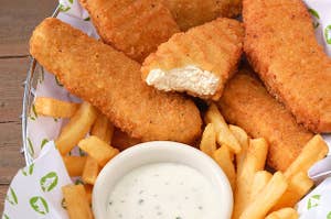 chicken nuggets in a basket with fries and dipping sauce