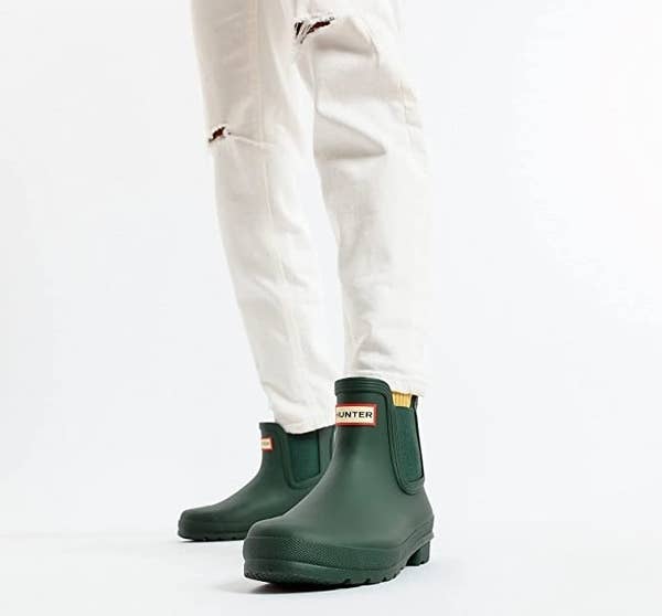 a model wearing the dark green Hunter boots