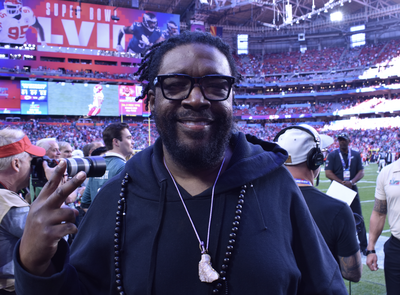 Questlove smiles and throws up the peace sign