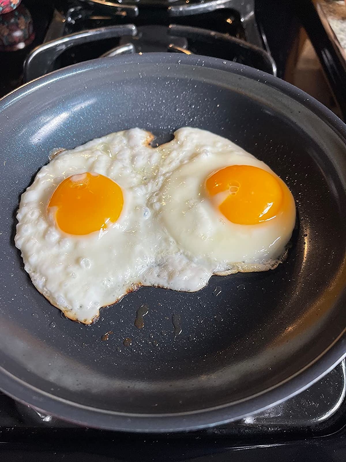 Reviewer&#x27;s photo of the 8-inch skillet in the color Blue with two eggs cooking inside