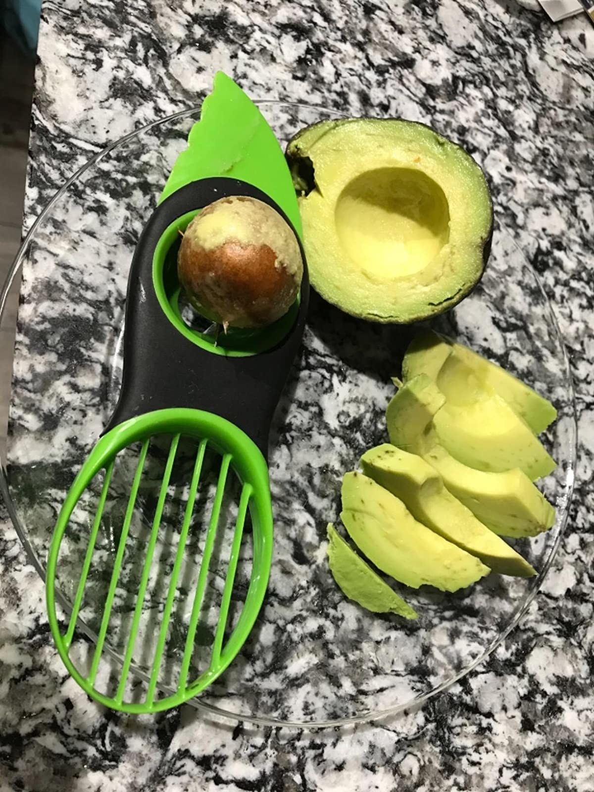 Reviewer&#x27;s photo of the avocado slicer with an avocado