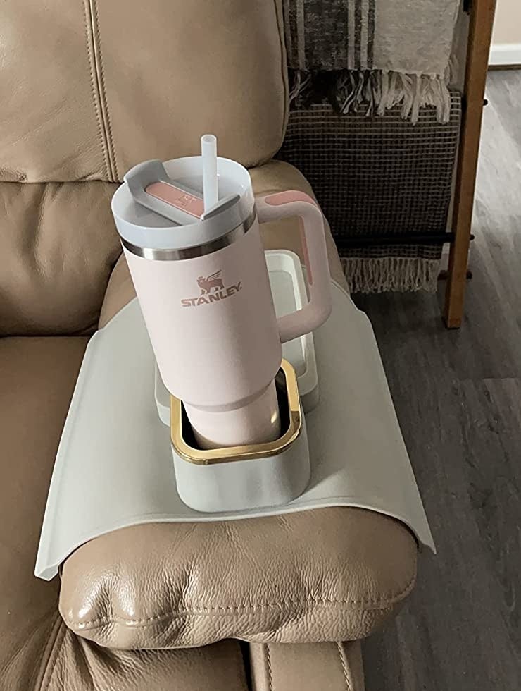 Reviewer image of a pink Stanley cup in their couch cup holder