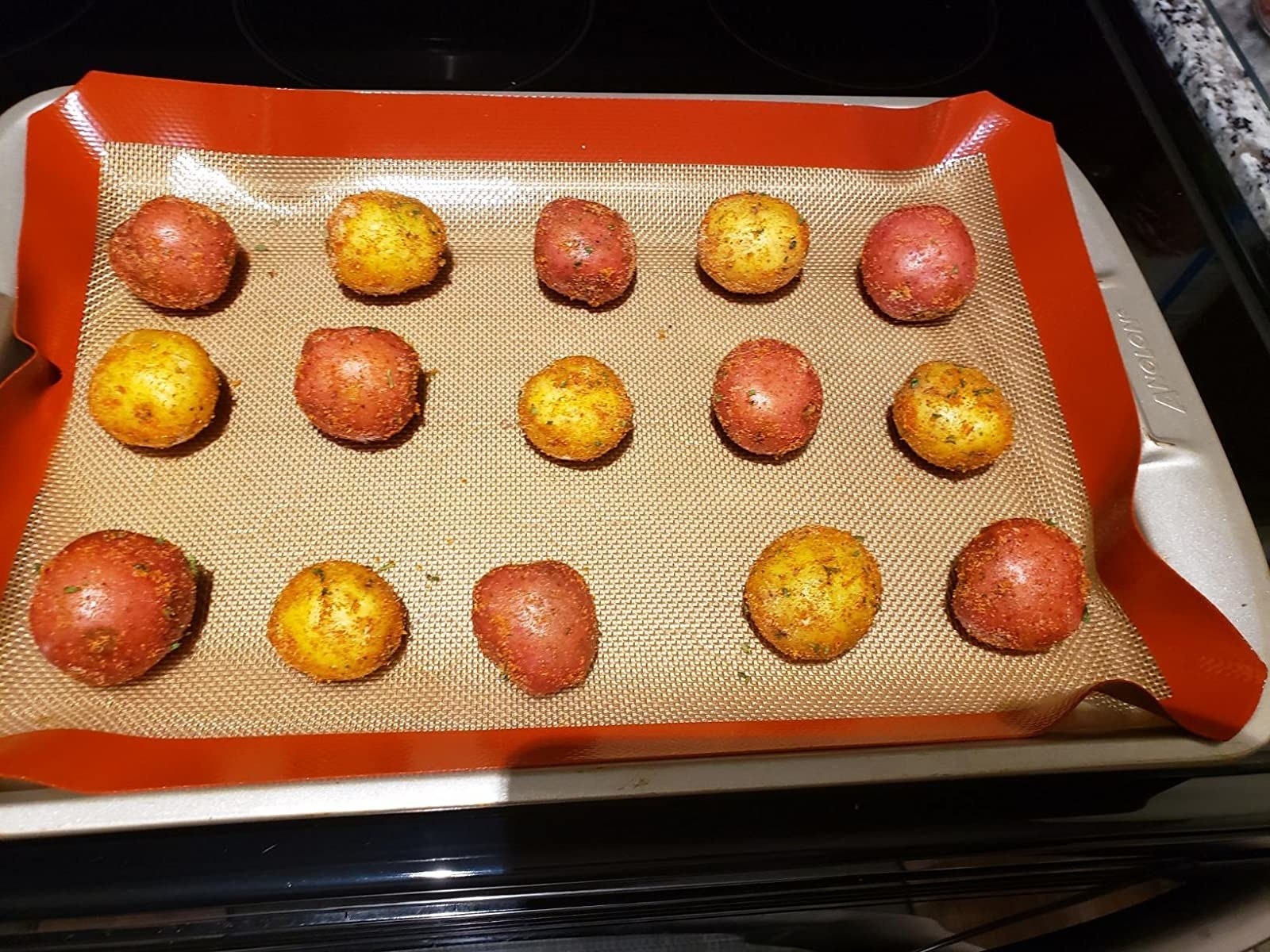 Reviewer&#x27;s photo of potatoes on red silicone baking mats