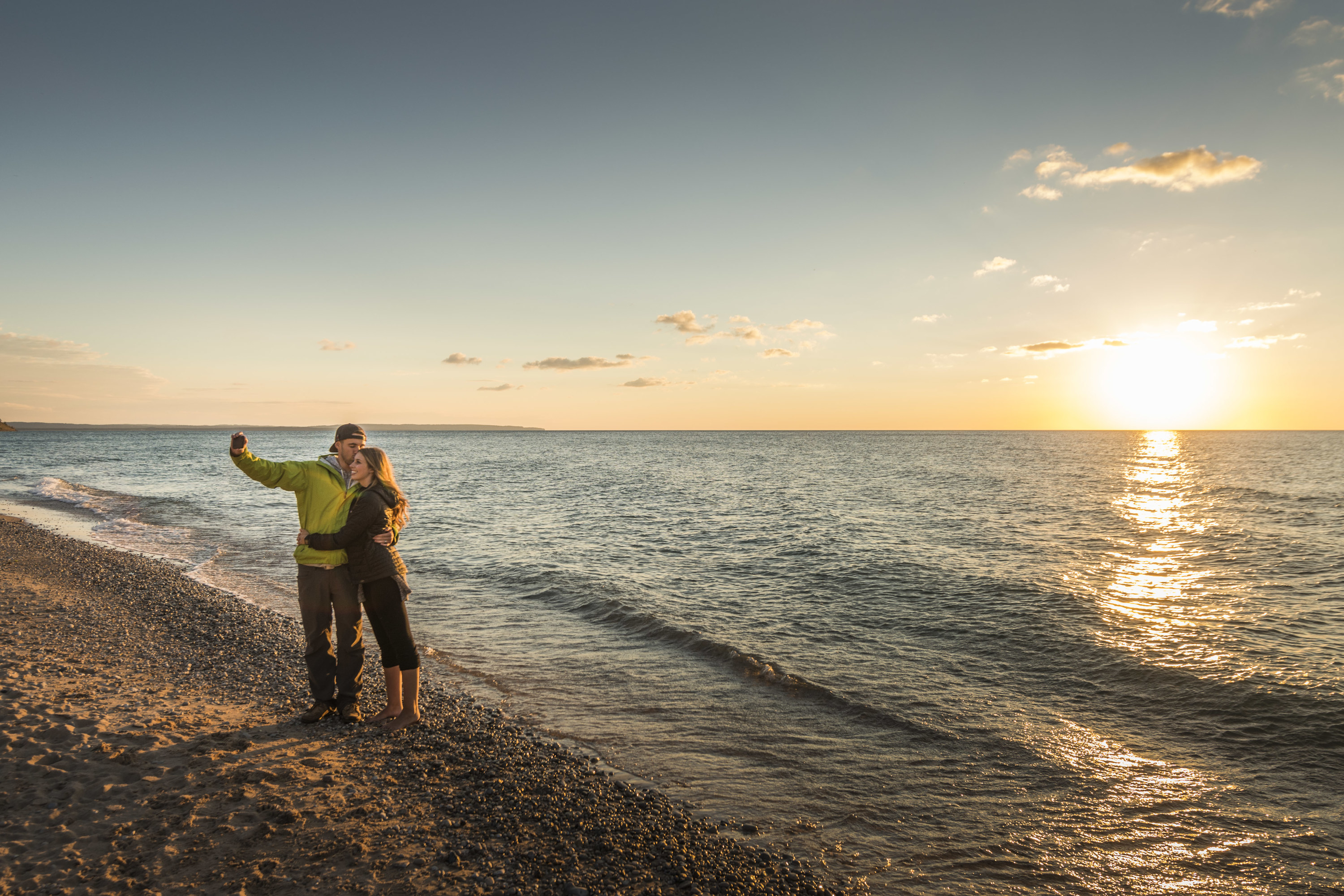 A couple takes a selfie by the water