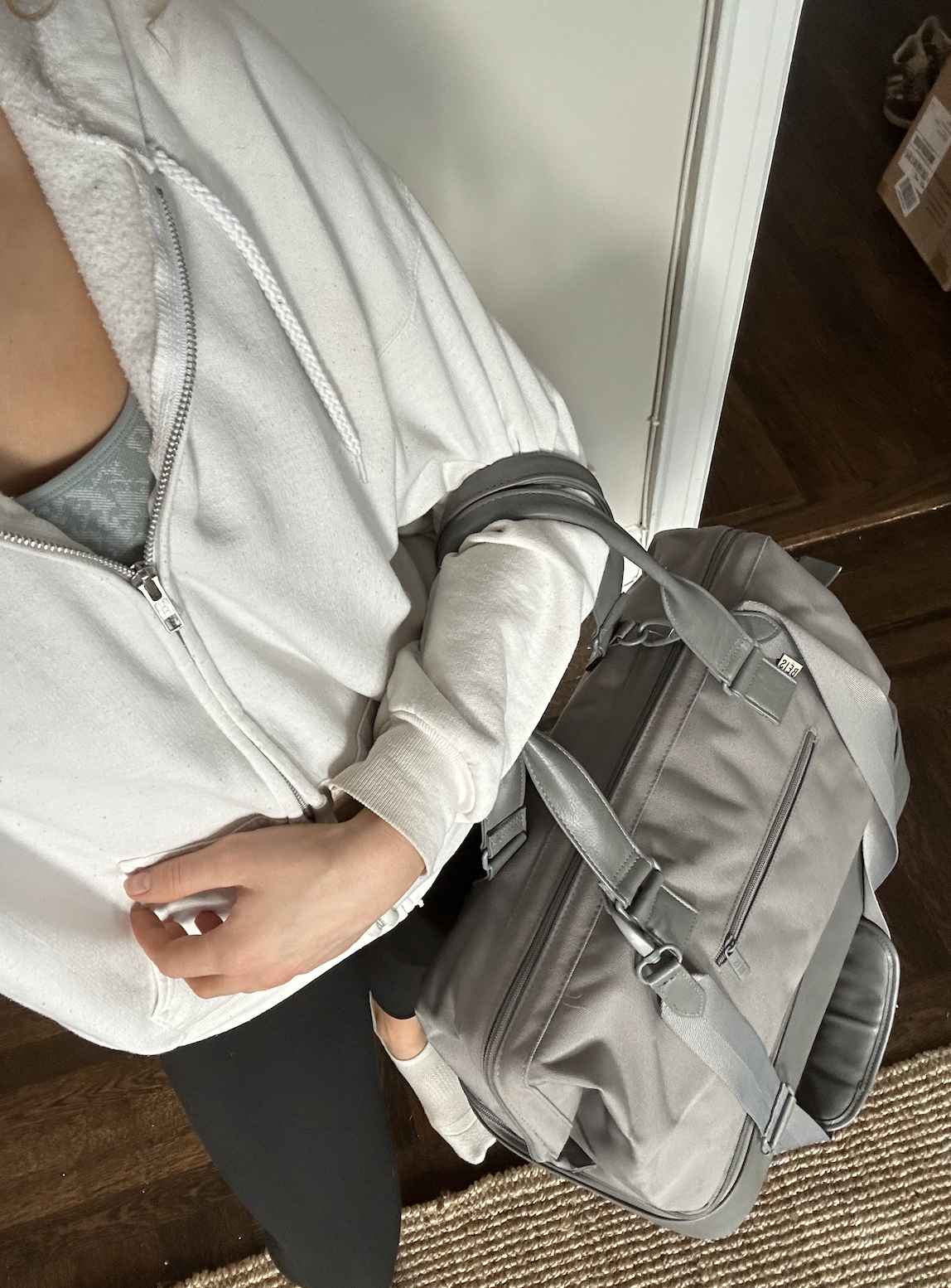 Abbey holding the gray weekender bag