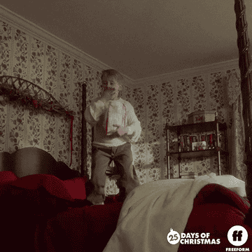 A gif of Kevin McCallister from &quot;Home Alone&quot; jumping on a bed