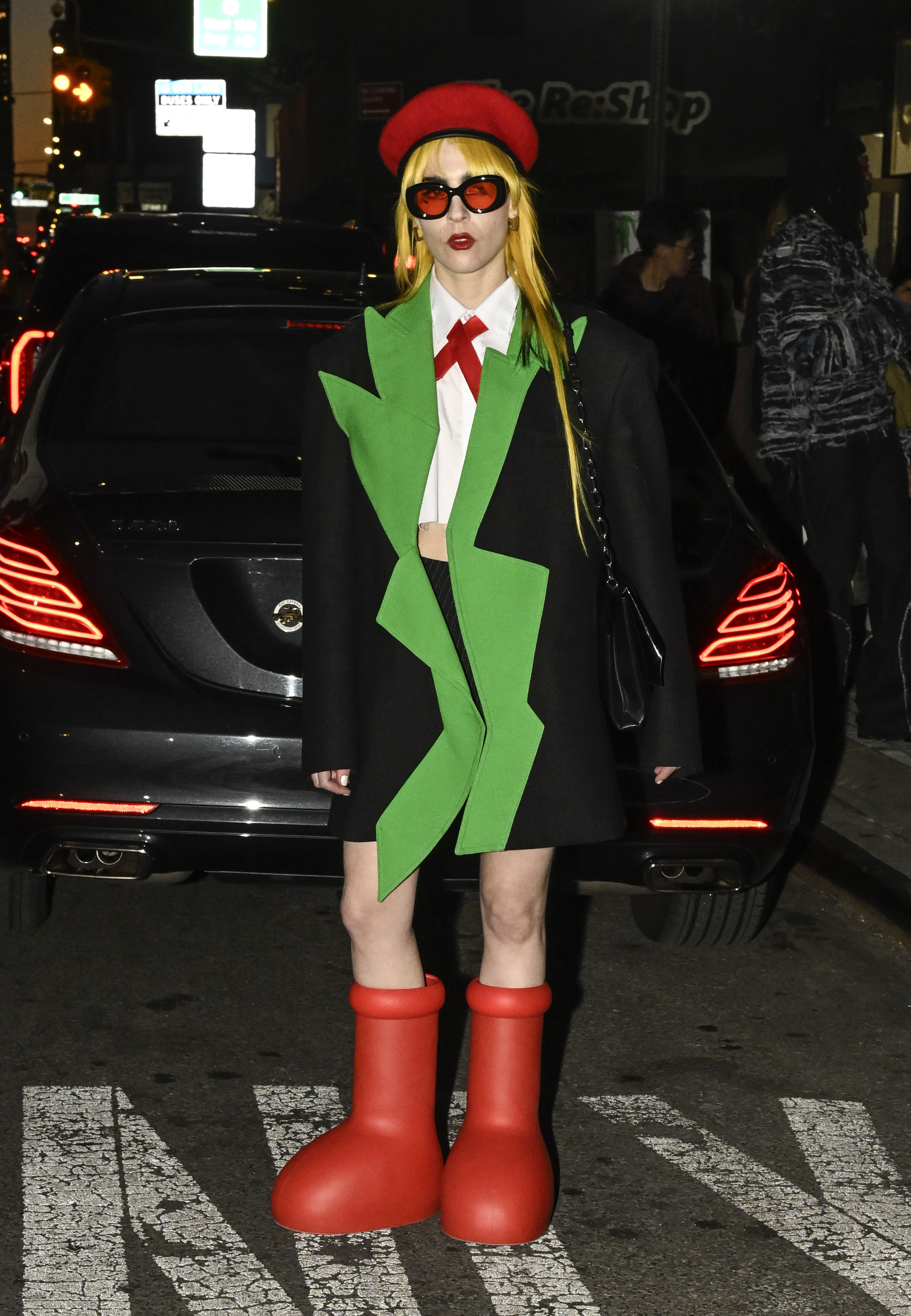 A guest is seen wearing a black and green jacket, white top, red beret, and the big red boots outside the Collina Strada show during New York Fashion Week on Feb. 10, 2023