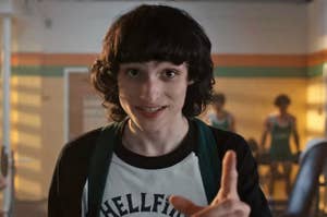 Finn Wolfhard pointing a finger and smiling as Mike on Stranger Things
