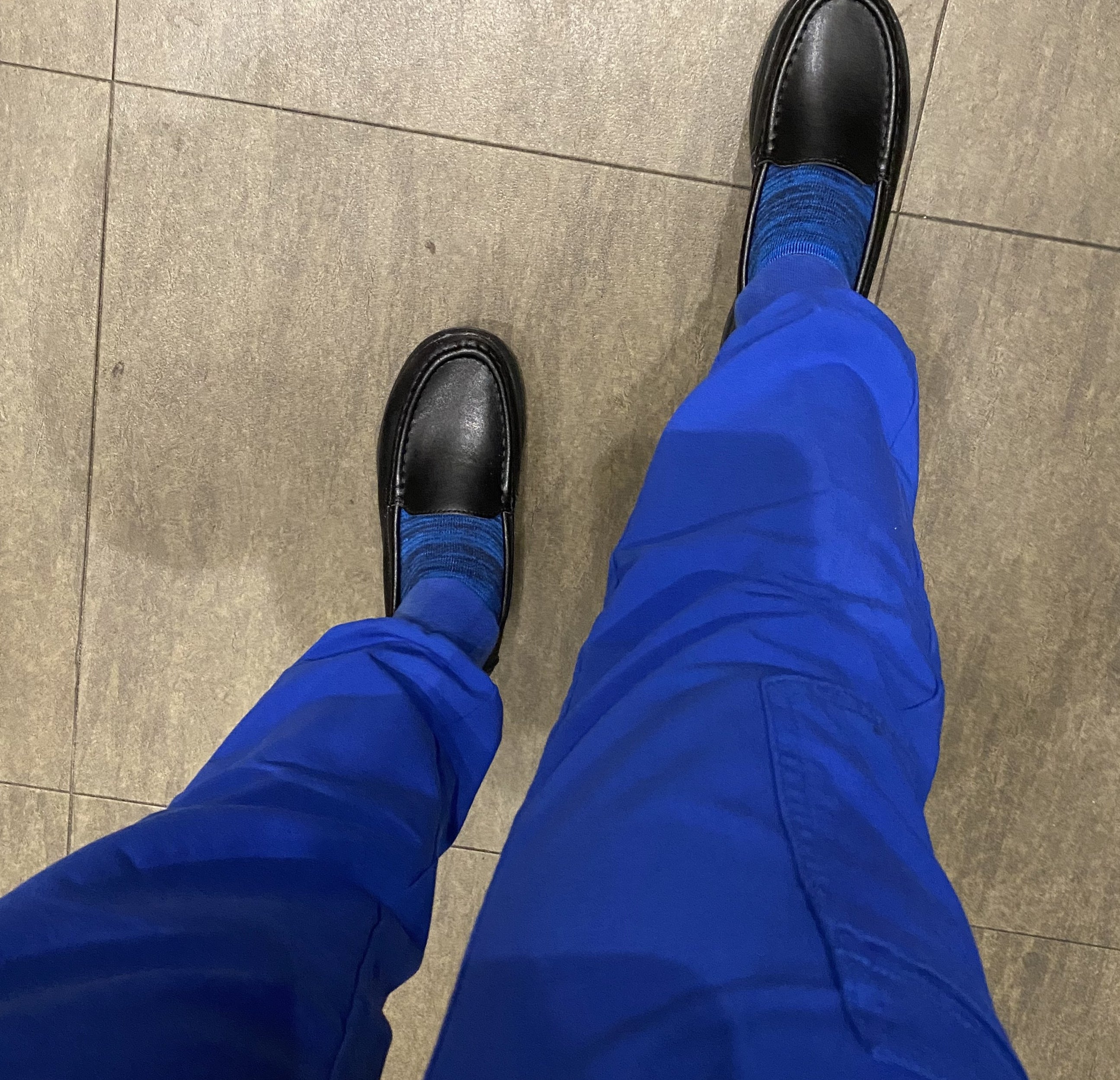 Reviewer wearing the black loafers with blue socks and scrubs