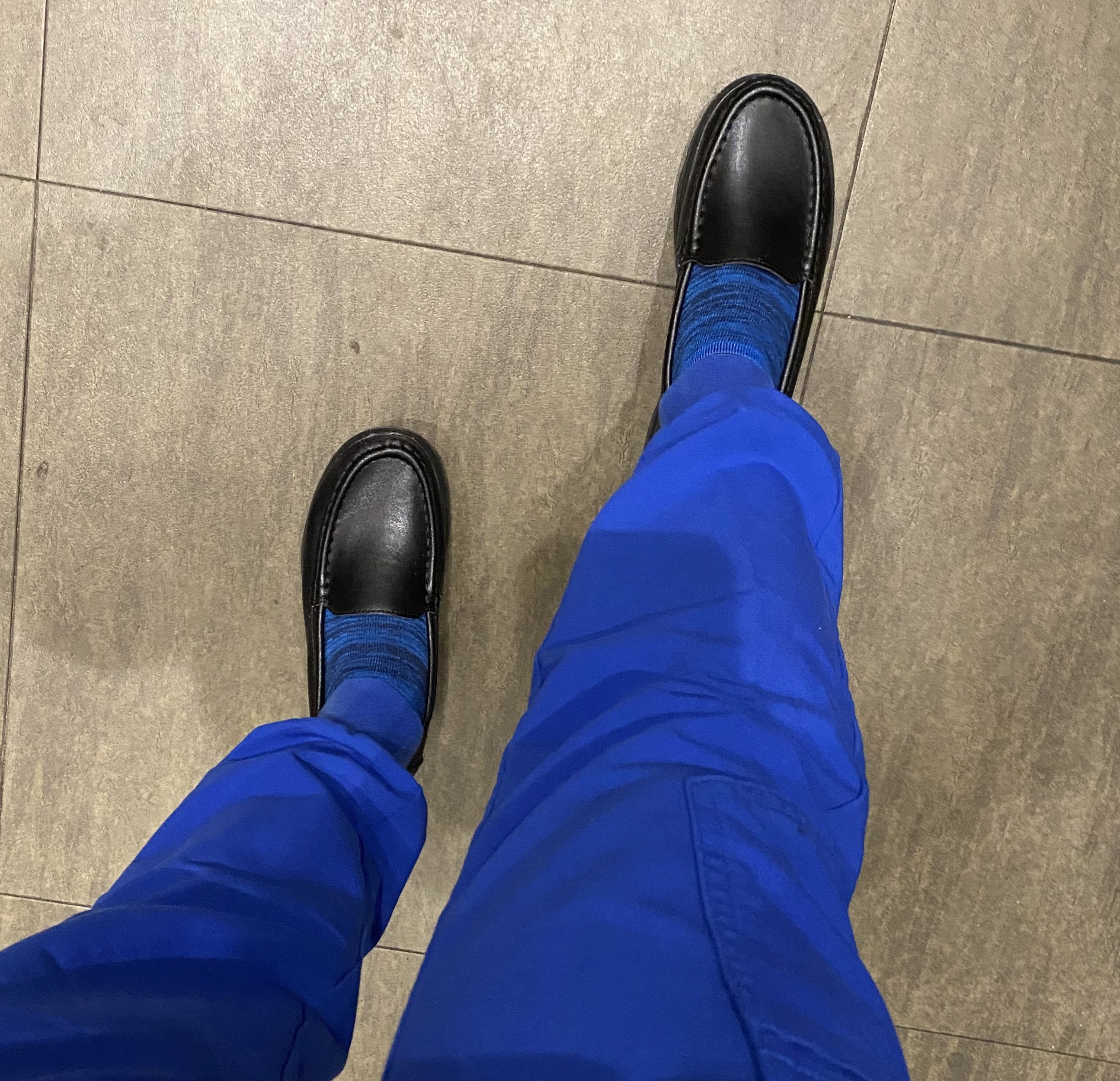 Reviewer wearing the black loafers with blue socks and scrubs