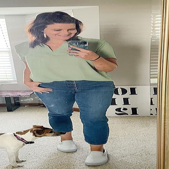 Reviewer wearing the top in a mint green color with jeans and slip-ons