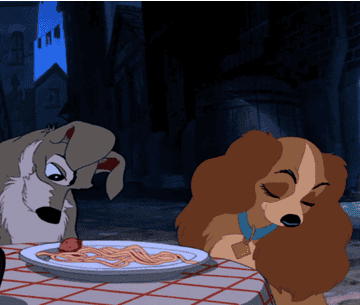 gif from lady and the tramp of tramp scooting a meatball across plate to lady