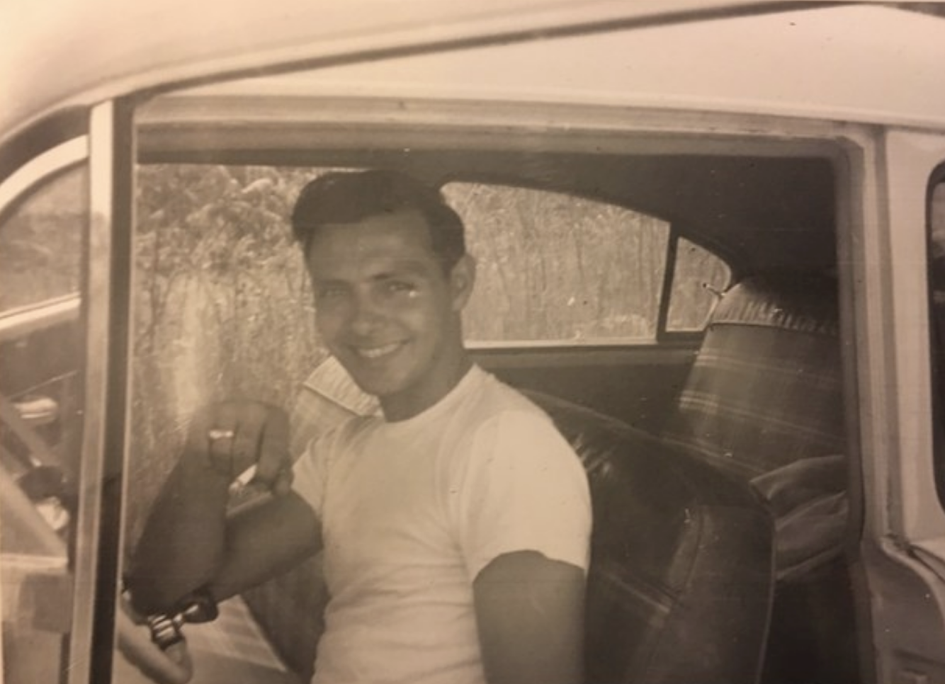 A young man in his old car