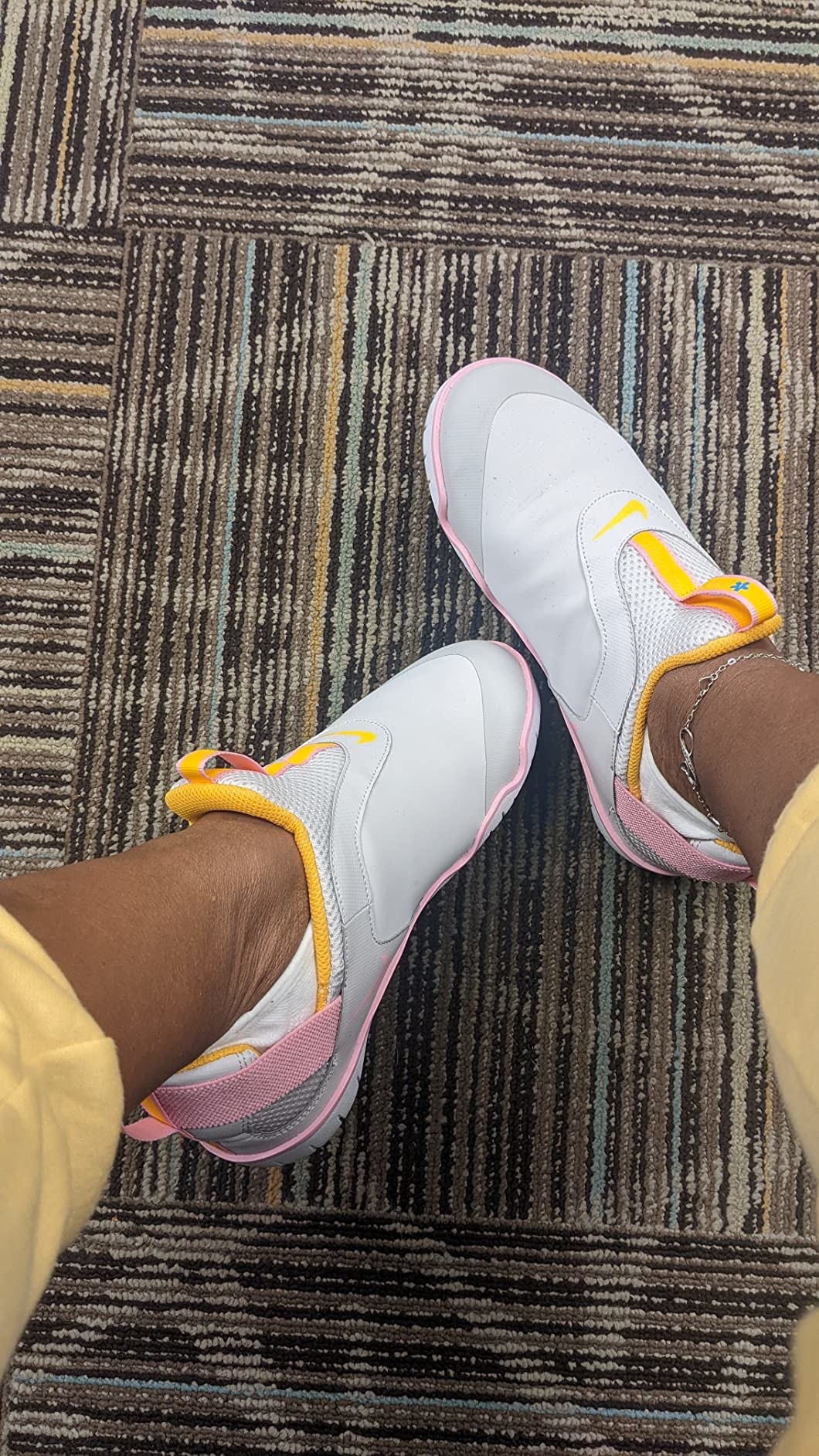 reviewer in the white sneakers featuring pink and yellow trim detailing