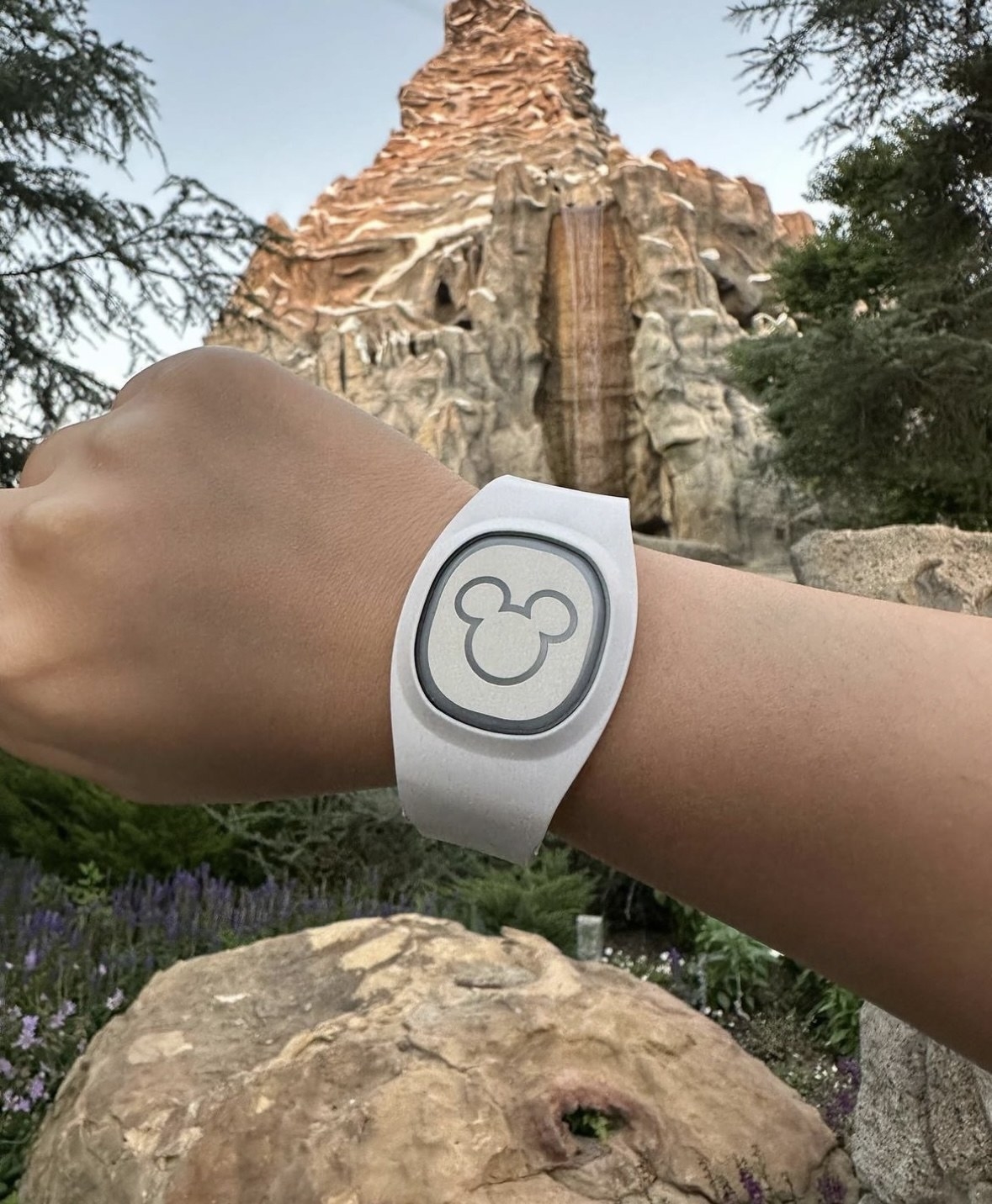 A photo of the MagicBand+ in front of Splash Mountain