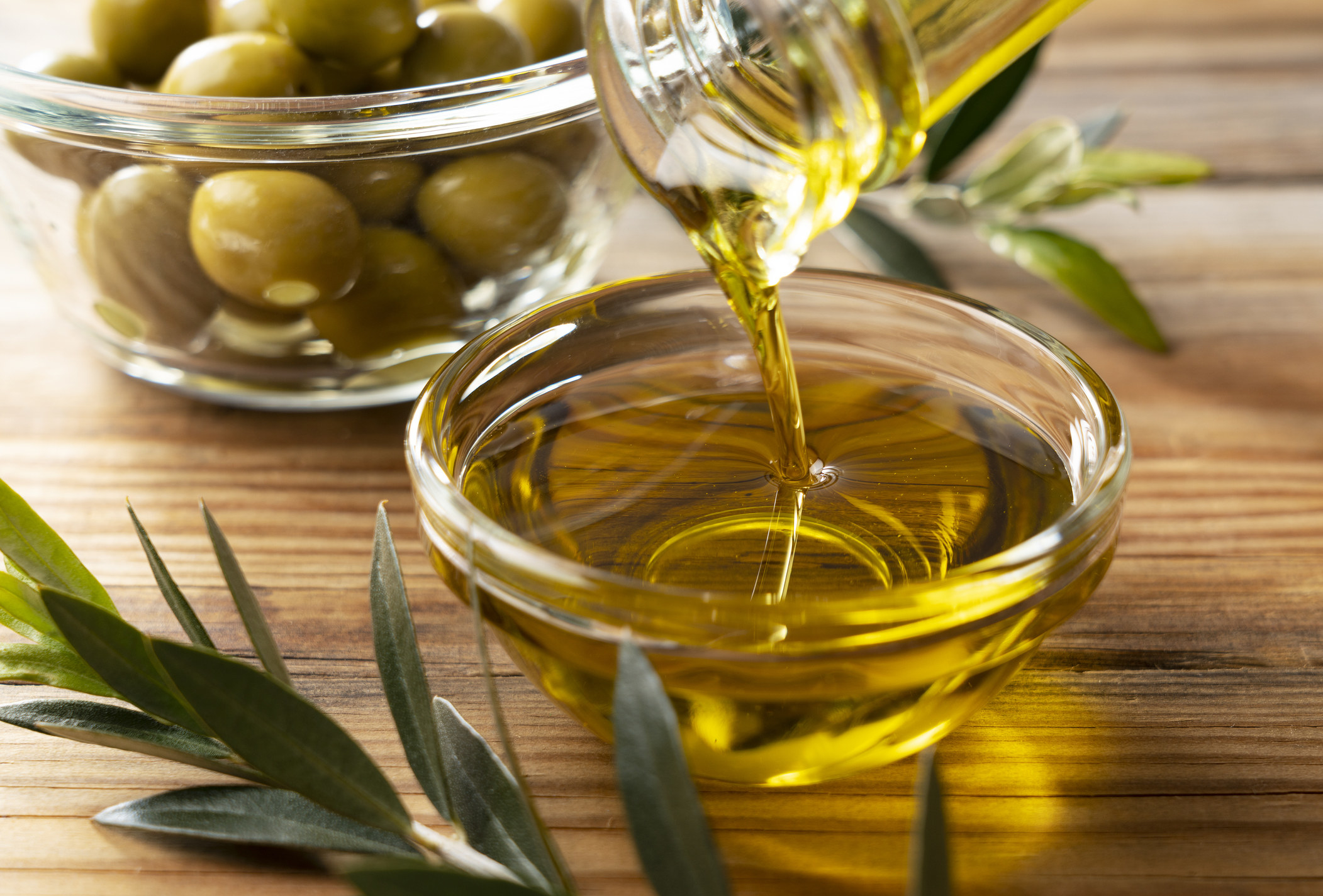 Olive oil pours into bowl