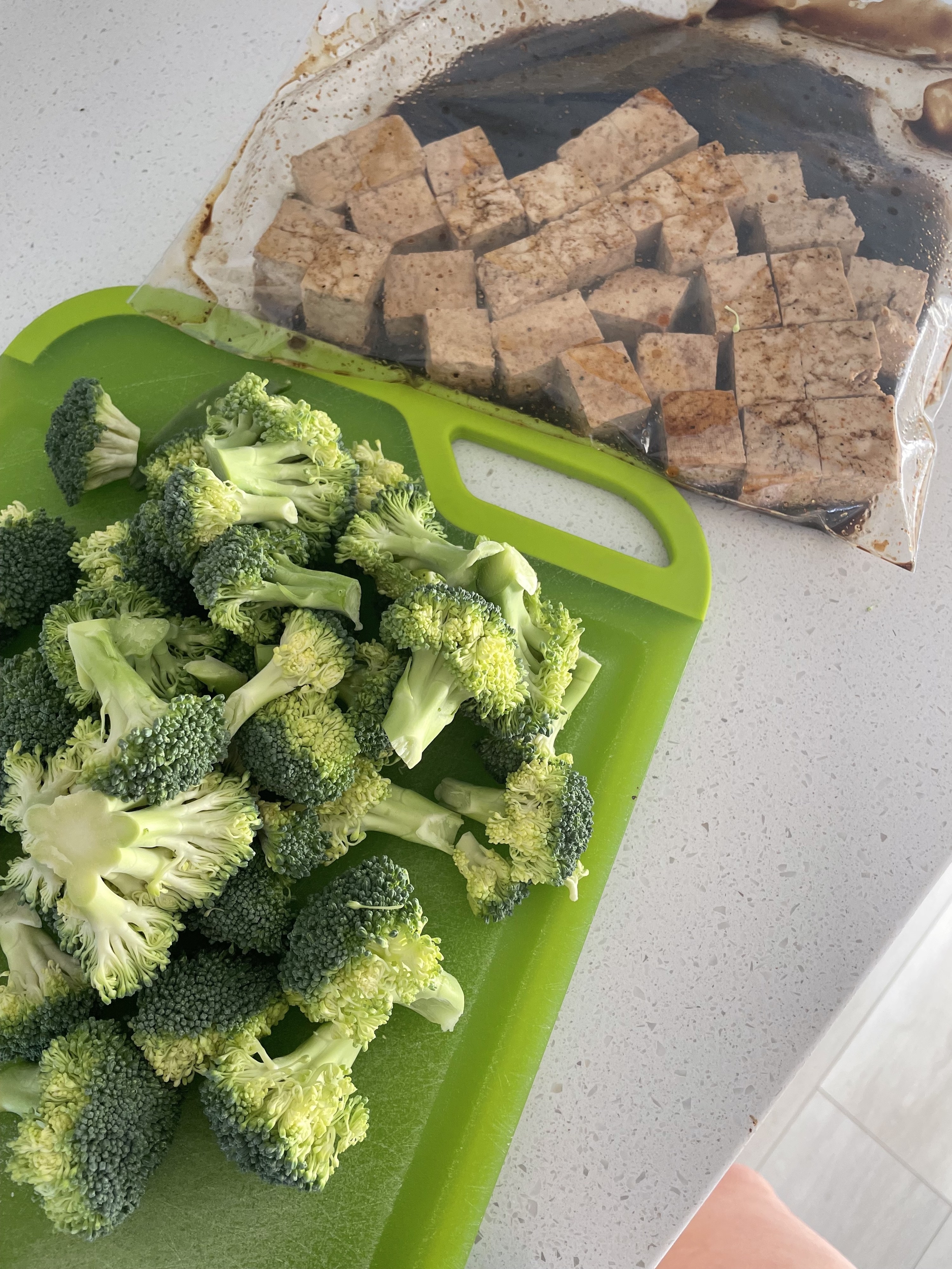 broccoli on a cutting board. tofu marinading