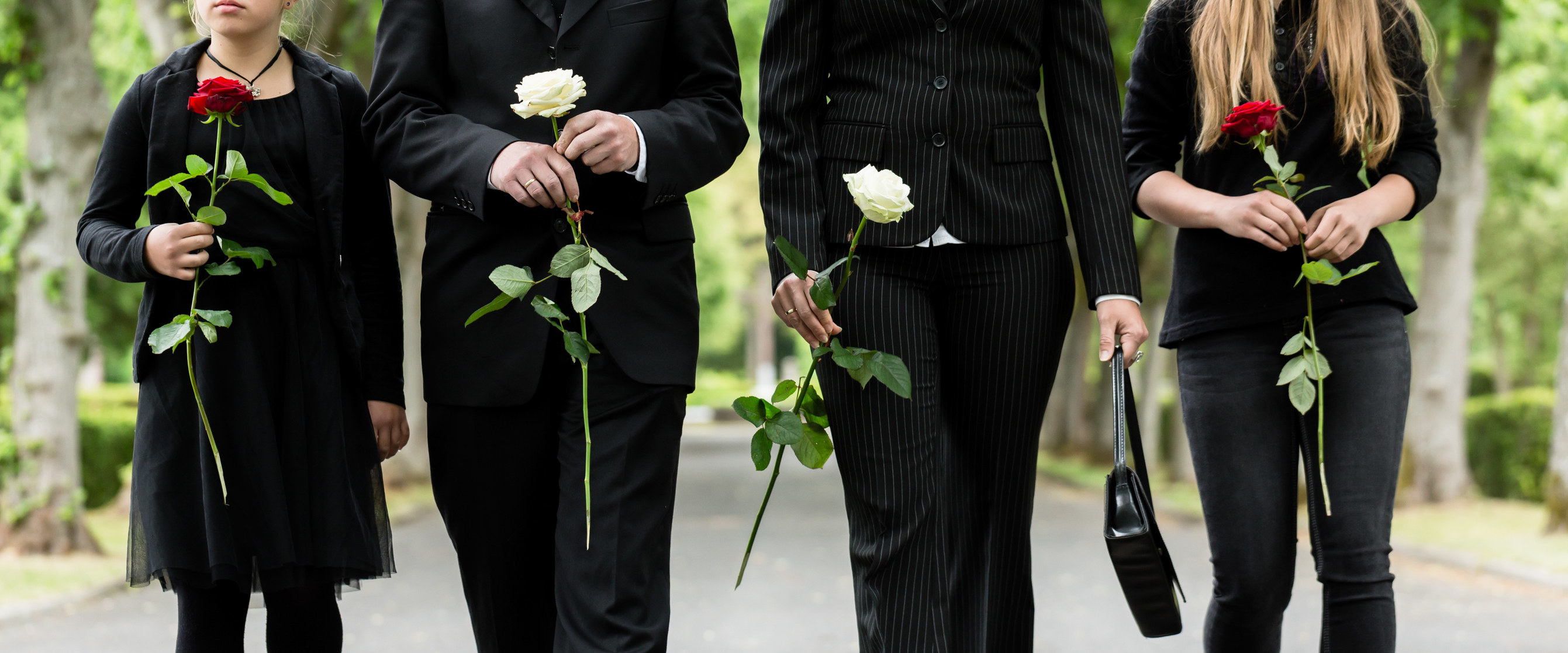 people dressed in black each carrying a single rose