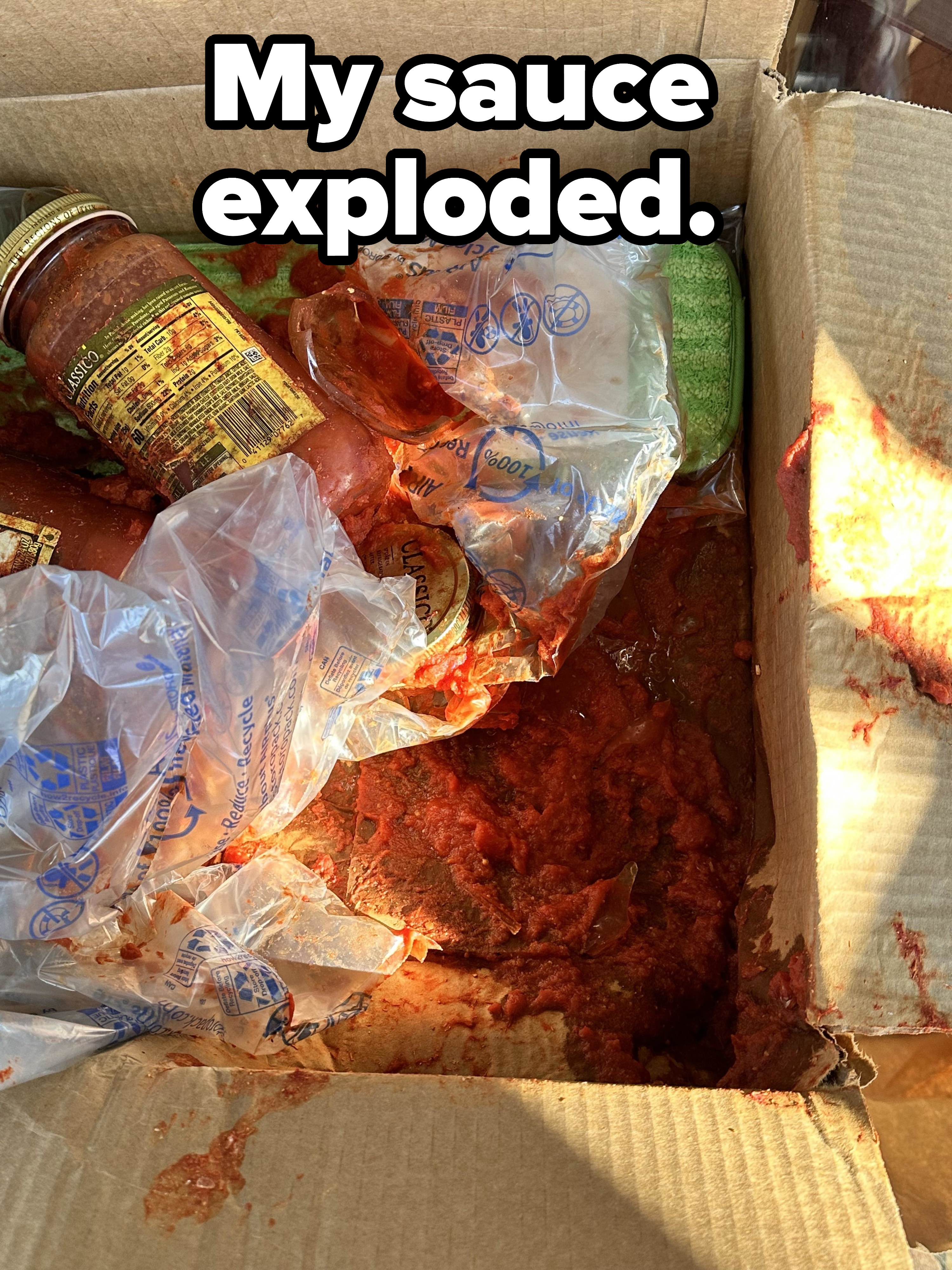 Exploded tomato sauce jar in a cardboard box