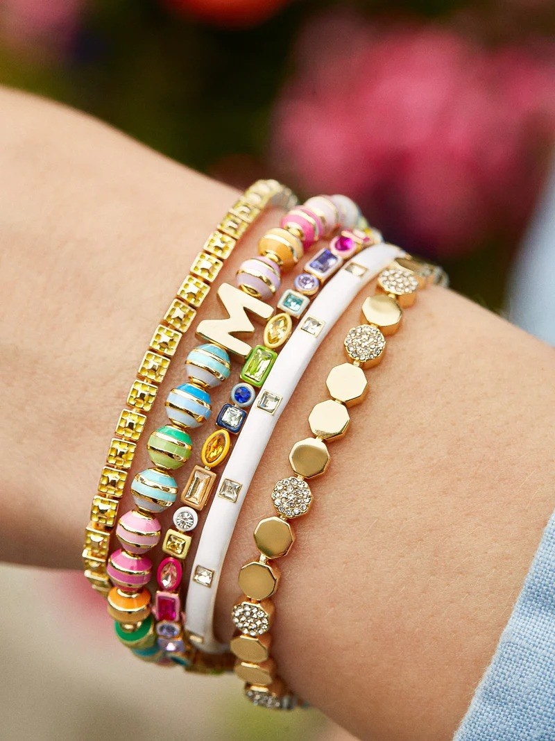model wearing stack of five different color bracelets