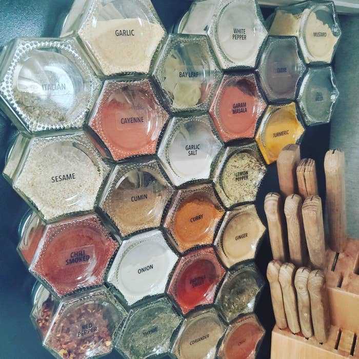 reviewer&#x27;s labeled glass jars on side of fridge filled with spices