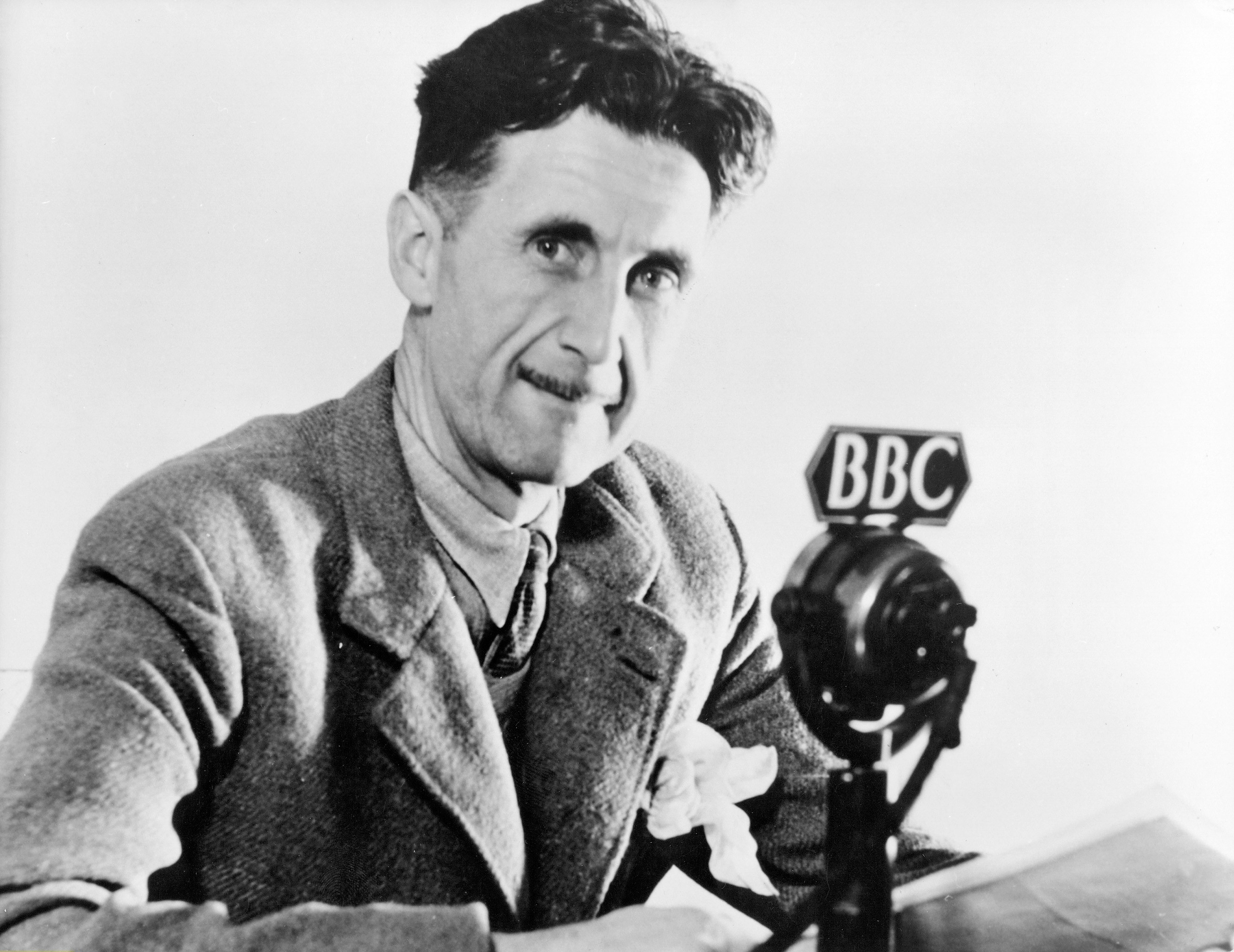 George Orwell sitting in front of a BBC microphone