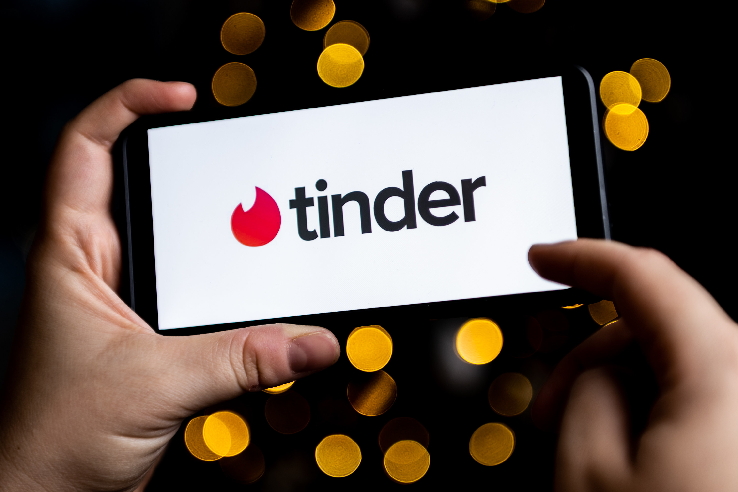 hands holding phone open to Tinder app