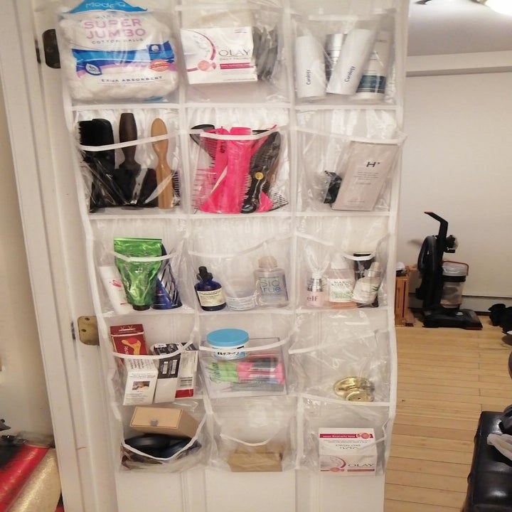 another reviewer showing organizer hanging on a bathroom closet door with toiletry items