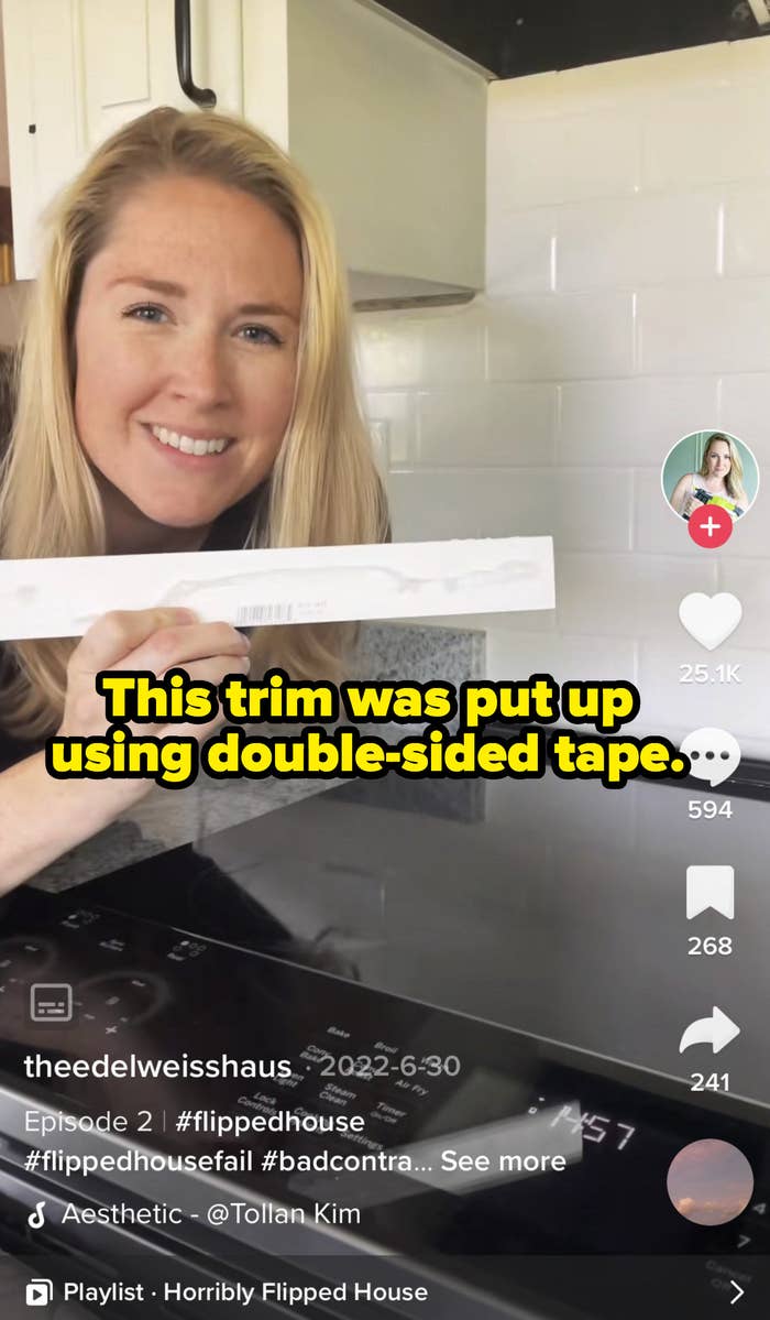 Kaitlin holding trim from her kitchen that was put on using double sided tape